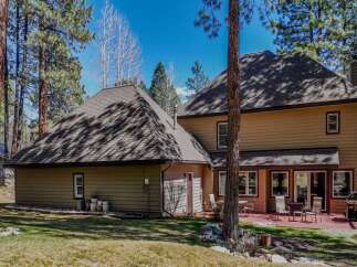 Nestled amidst towering trees, this stunning property boasts a spacious layout and inviting outdoor spaces.