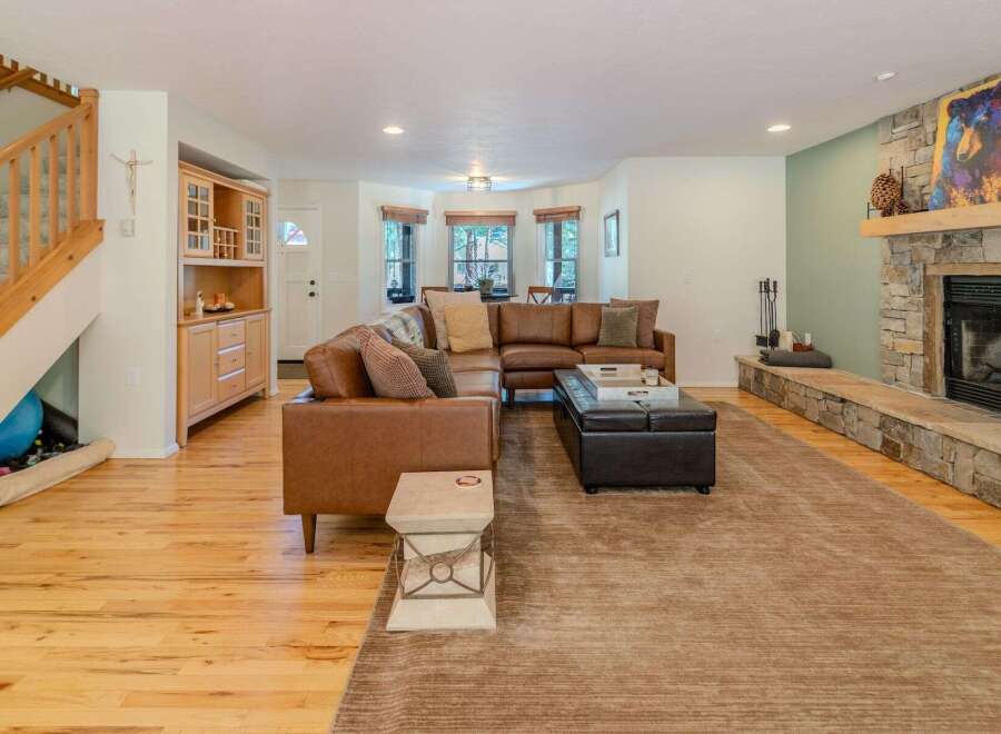 Step into luxury with this stunning living room, featuring a cozy sectional sofa and a beautiful stone fireplace.