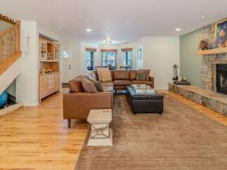 Step into luxury with this stunning living room, featuring a cozy sectional sofa and a beautiful stone fireplace.