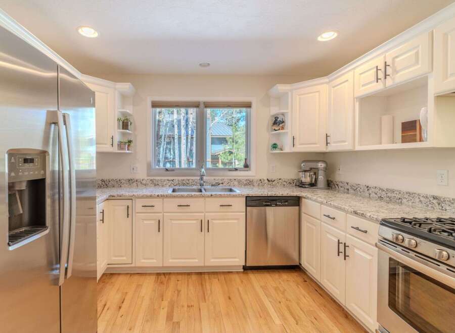 Step into this stunning kitchen, featuring sleek stainless steel appliances and pristine white cabinetry.