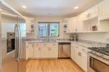 Step into this stunning kitchen, featuring sleek stainless steel appliances and pristine white cabinetry.