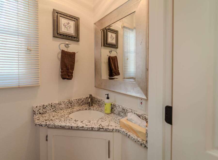 This charming bathroom features a stylish vanity with a granite countertop, offering both elegance and practicality.