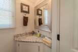 This charming bathroom features a stylish vanity with a granite countertop, offering both elegance and practicality.