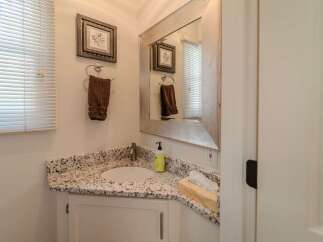 This charming bathroom features a stylish vanity with a granite countertop, offering both elegance and practicality.