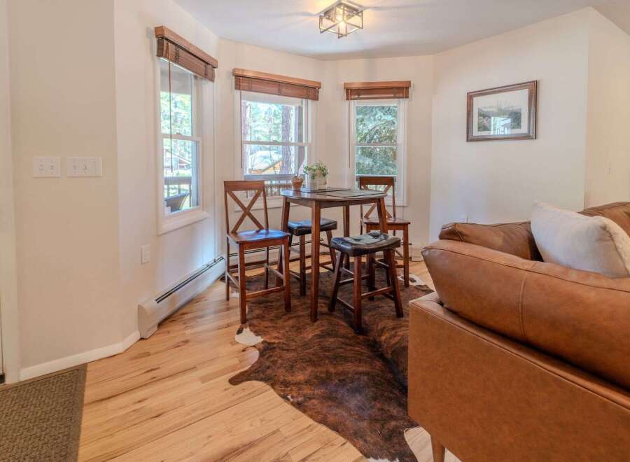 Step into this inviting space, featuring a cozy dining area with a charming round table and stylish bar stools.