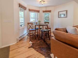 Step into this inviting space, featuring a cozy dining area with a charming round table and stylish bar stools.