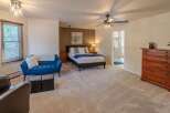 This spacious bedroom offers a serene retreat with its plush carpeting and ample natural light.