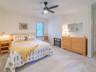 This inviting bedroom boasts a cozy atmosphere with its plush carpet and natural light.