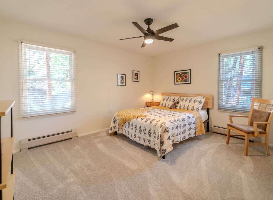 This inviting bedroom features a cozy queen-sized bed with stylish bedding, perfect for a restful night's sleep.
