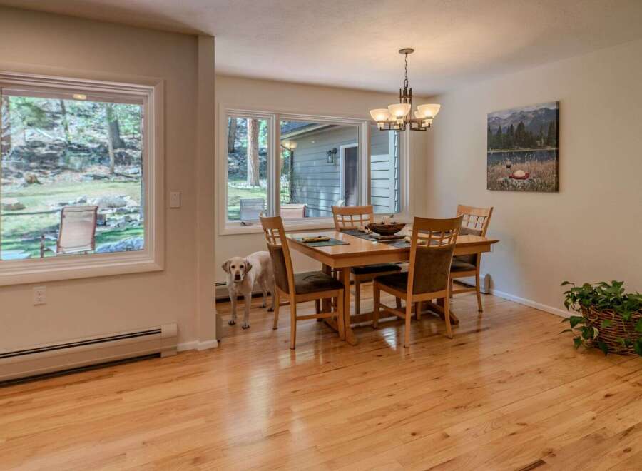 This inviting dining room features a beautiful hardwood floor and a stylish chandelier, creating a warm and welcoming atmosphere.