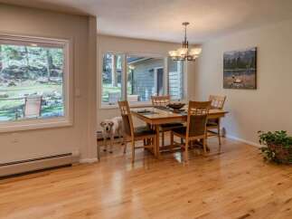 This inviting dining room features a beautiful hardwood floor and a stylish chandelier, creating a warm and welcoming atmosphere.