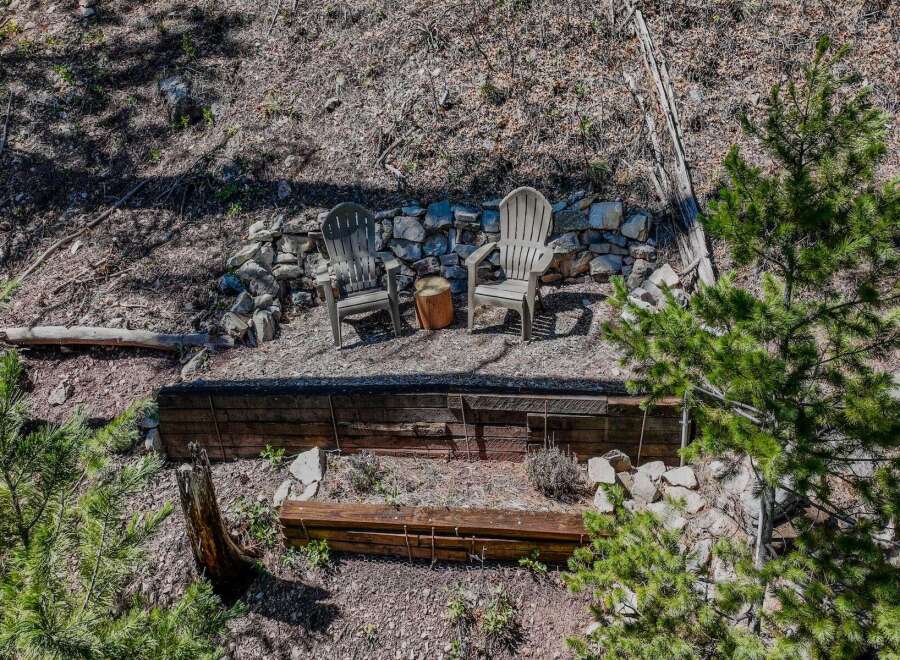 Discover a serene outdoor retreat with this property, featuring a charming seating area perfect for relaxation.