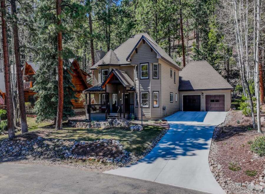 Nestled in a serene, wooded setting, this stunning property boasts a charming two-story home with a welcoming porch.