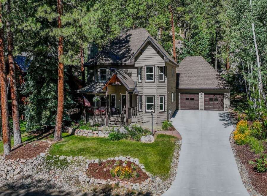 Nestled amidst towering pine trees, this charming home offers a serene mountain retreat.