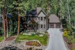 Nestled amidst towering pine trees, this charming home offers a serene mountain retreat.