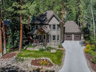 Nestled amidst towering pine trees, this charming home offers a serene mountain retreat.