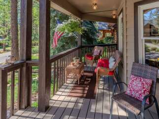 Enjoy the serene mountain lifestyle from this charming covered porch, perfect for relaxing with a morning coffee or evening drink.