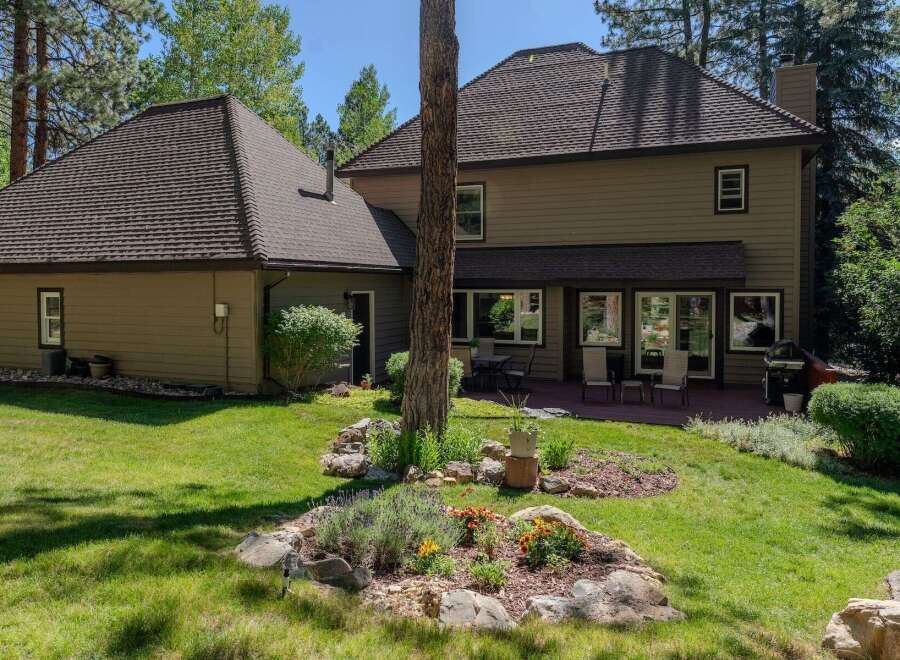 Enjoy outdoor living in this spacious backyard featuring a large wooden deck perfect for entertaining.