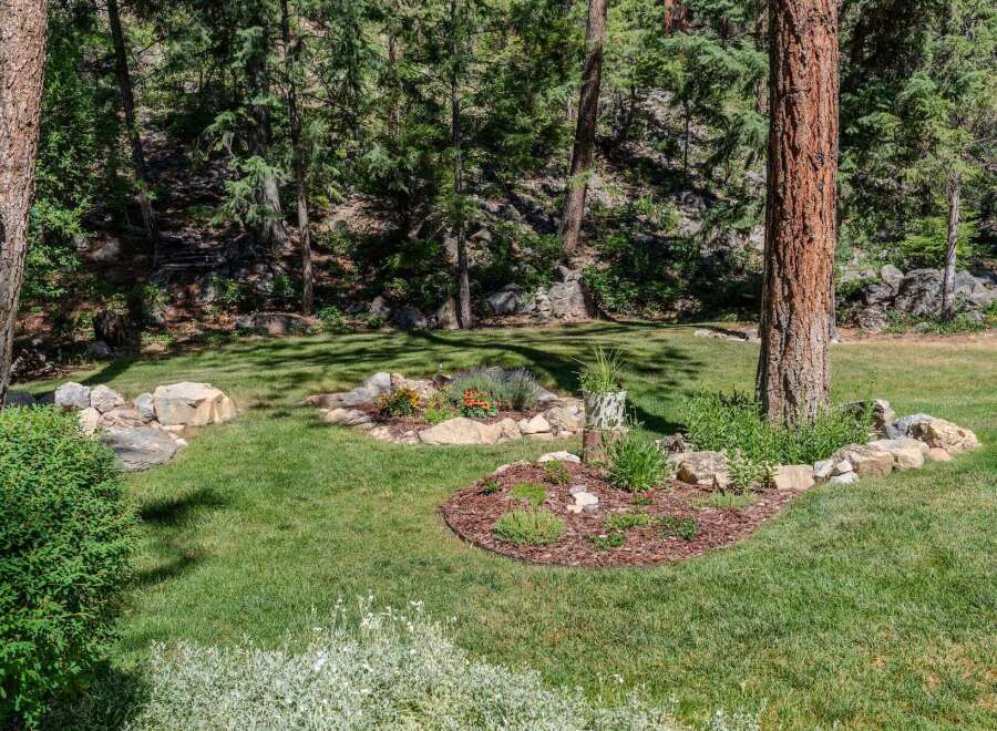 Discover a serene backyard oasis with lush green lawns and mature trees providing ample shade.