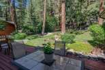 Enjoy the serene mountain lifestyle from this charming log cabin's expansive deck, perfect for outdoor dining and relaxation.