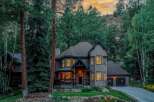Nestled amidst towering pine trees and a scenic mountain backdrop, this stunning home offers a serene retreat.