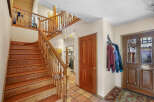 This stunning property features a grand staircase with beautiful wooden steps and railings, creating an inviting entrance.