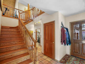 This stunning property features a grand staircase with beautiful wooden steps and railings, creating an inviting entrance.