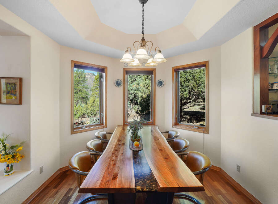 This stunning dining room showcases a unique live-edge wooden table, perfect for hosting gatherings.