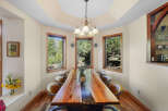 This stunning dining room showcases a unique live-edge wooden table, perfect for hosting gatherings.