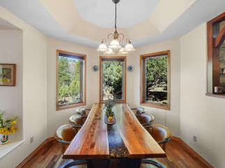 This stunning dining room showcases a unique live-edge wooden table, perfect for hosting gatherings.