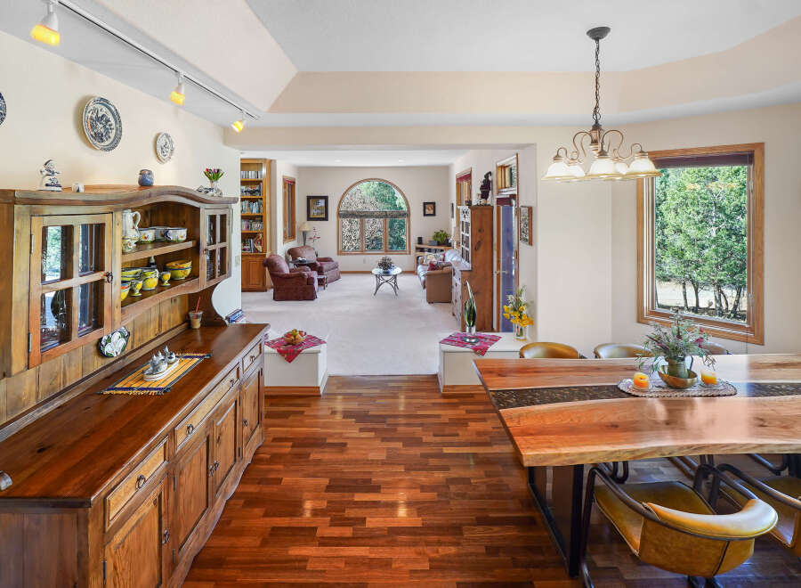 Step into this inviting dining room, showcasing a stunning live-edge wooden table and stylish chairs.