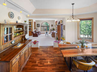 Step into this inviting dining room, showcasing a stunning live-edge wooden table and stylish chairs.