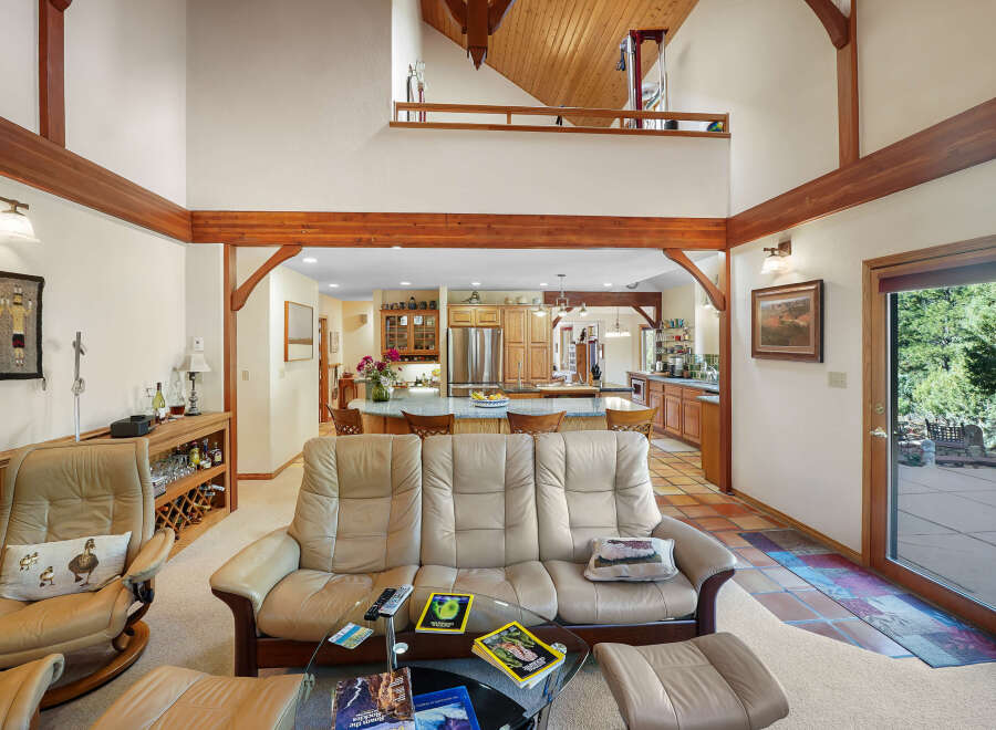 Step into luxury with this stunning property featuring a spacious living area with high ceilings and exposed wooden beams.