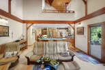 Step into luxury with this stunning property featuring a spacious living area with high ceilings and exposed wooden beams.