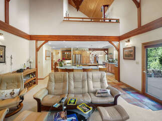 Step into luxury with this stunning property featuring a spacious living area with high ceilings and exposed wooden beams.
