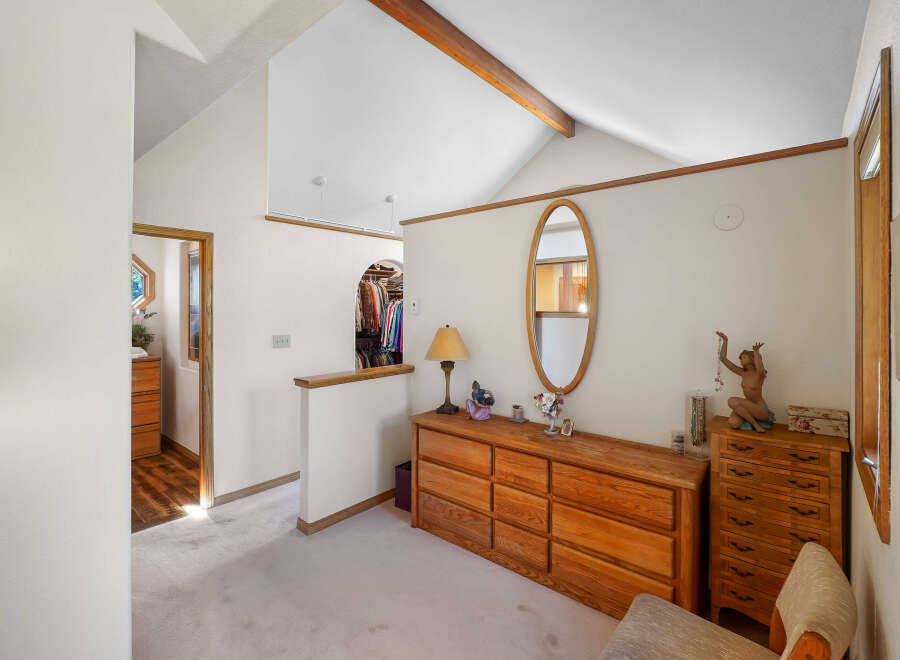 This charming bedroom features a spacious layout with a vaulted ceiling and a warm, inviting atmosphere.