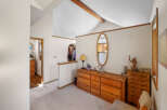 This charming bedroom features a spacious layout with a vaulted ceiling and a warm, inviting atmosphere.