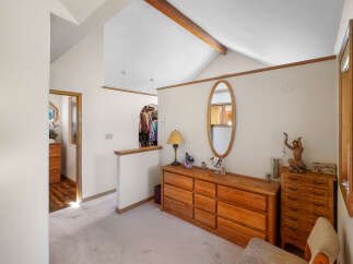 This charming bedroom features a spacious layout with a vaulted ceiling and a warm, inviting atmosphere.