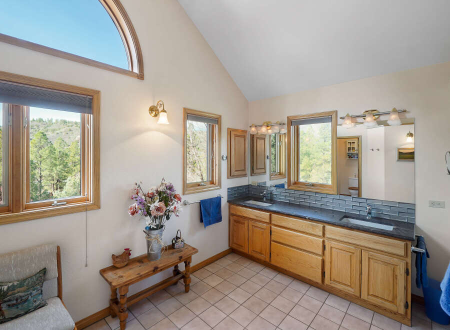 This stunning bathroom boasts a unique design with a vaulted ceiling and an arched window, creating a bright and airy atmosphere.