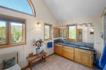 This stunning bathroom boasts a unique design with a vaulted ceiling and an arched window, creating a bright and airy atmosphere.