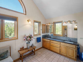 This stunning bathroom boasts a unique design with a vaulted ceiling and an arched window, creating a bright and airy atmosphere.