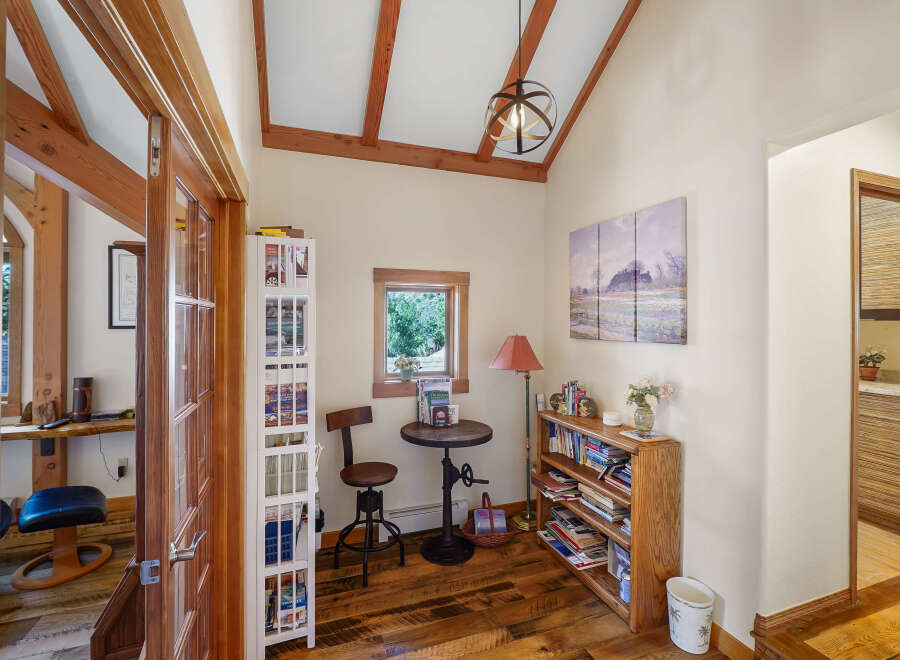 Step into this inviting home office, featuring a charming reading nook with a small round table and a unique adjustable stool.