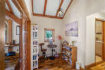 Step into this inviting home office, featuring a charming reading nook with a small round table and a unique adjustable stool.