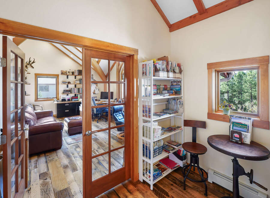 Step into this inviting home office, featuring a rustic wood floor and a stunning view.