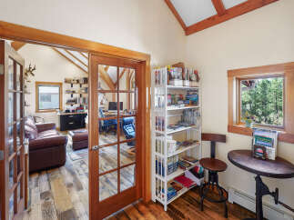 Step into this inviting home office, featuring a rustic wood floor and a stunning view.
