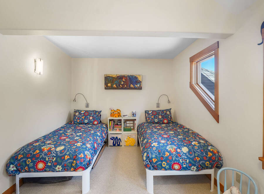 This charming bedroom features two twin beds with vibrant floral bedding, perfect for a shared space or guest room.
