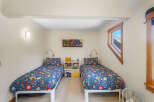 This charming bedroom features two twin beds with vibrant floral bedding, perfect for a shared space or guest room.