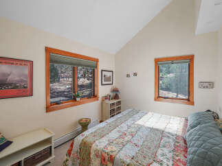 This charming bedroom offers a cozy retreat with its inviting ambiance and natural light.