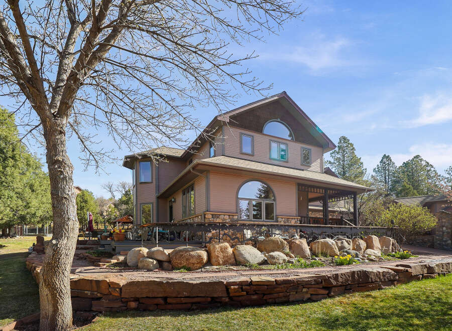 This stunning property boasts a beautiful exterior with a multi-level design and a charming stone facade.