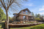 This stunning property boasts a beautiful exterior with a multi-level design and a charming stone facade.